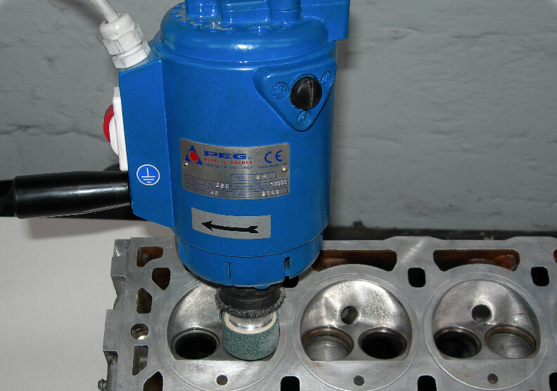 Peg orbital grinder refacing the valve seats of a cylinder head